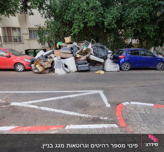 ערימת רהיטים ופסולת ברחוב ליד מכוניות חונות